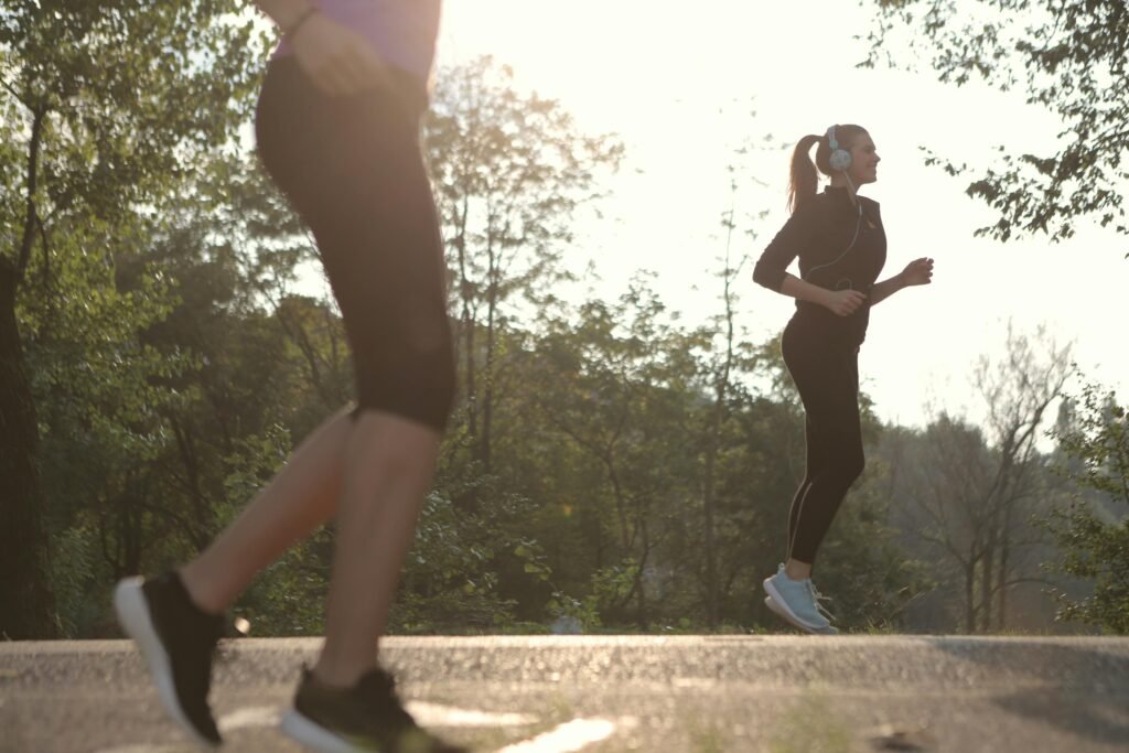 Mulher a correr ao ar livre num percurso arborizado